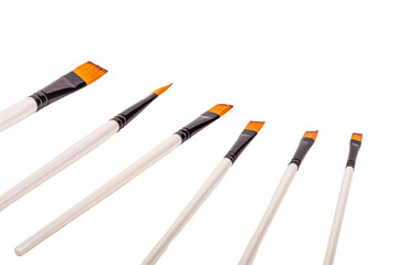 Brushes lined up for painting projects in an artistic workspace with bright colors and creative tools
