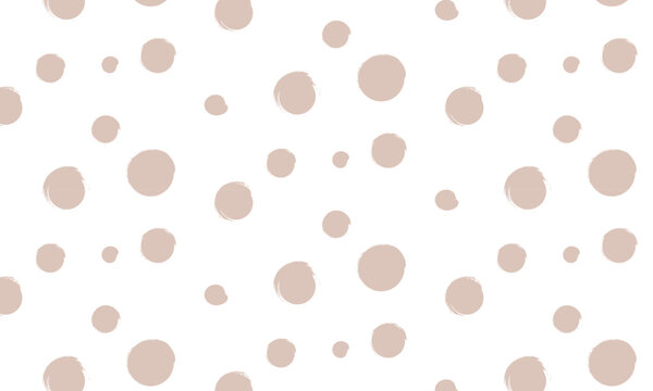 Hand drawn dotted seamless pattern in grungy style. rough organic hand drawn polka pattern in pinkish beige color.