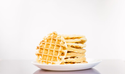 many delicious waffles on a plate for breakfast on a light background