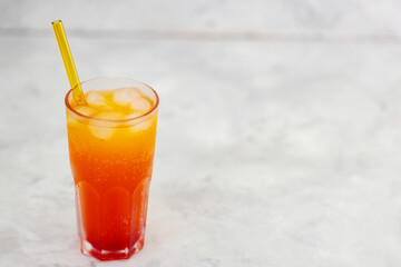 Dirty Soda with Yellow Straw in Tall Glass on Gray Background, Copy Space