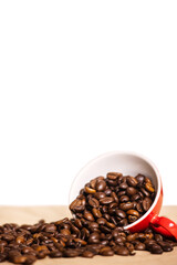 red cup with coffee beans on a light background.