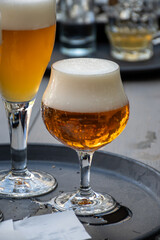 Belgian beer in glass in old brewery in Bruges, strong triple, tasty beverage, lunch with beer, tourist destination, Flanders, Belgium