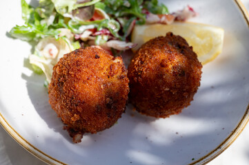 Lunch in cafe with vegetarian cheese and green asparagus croquettes served with fresh salad and french fries potato in Bruges, Belgium