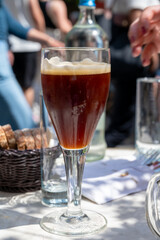 Belgian beer in glass in old brewery in Bruges, dubbel dark, tasty beverage, lunch with beer, tourist destination, Flanders, Belgium