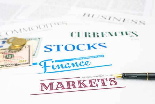 Financial markets, investments, and economic news : Currency notes, coins, and a pen placed on papers, symbolizing financial transactions, investments, currency, business, and stock market analysis.