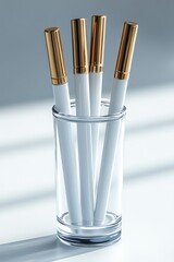 Four white pens in a clear glass