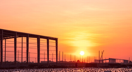 Silhouette two industry warehouse factory building structure in construction site against colorful...