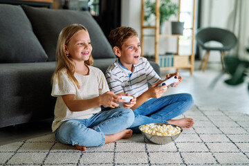 child girl boy brother sister game playing gamer video  console computer joystick together...