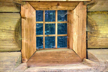  a small square window in an old wooden house of a wealthy Ukrainian peasant