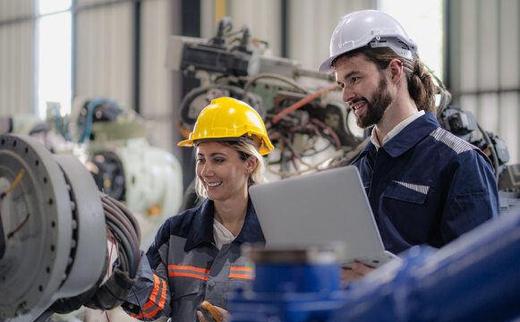Robotic engineer team standing together meeting at factory discussing electronic robot machine engineering. AI high tech production technician teamwork working at futuristic technology manufacturing