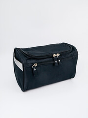 Black travel bag for cosmetics on white background