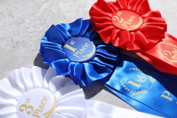 Different award ribbons on light grey table, closeup