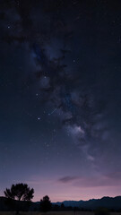 A streak of stars in the early, morning sky. Lightly illuminated ground, trees, hills.