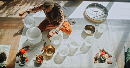 Sound therapy, woman and healing with naturopath with bowls, ceremony and culture from above....