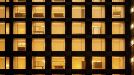 Contemporary Glass Architecture with Warm Yellow Lights in Office Windows