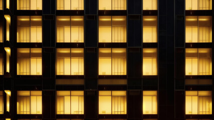 Modern Office Building Facade with Yellow Lit Windows at Night