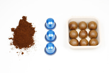 Comparison of traditional aluminum coffee capsules and biodegradable organic pods with ground coffee on white background