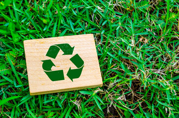 Top view of close up Recycle symbol on wooden block with customizable space for text. For a greener...