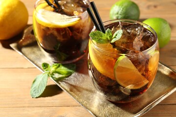 Refreshing Cuba libre cocktail with mint on wooden table, closeup