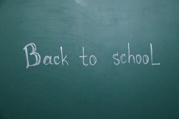 Obraz premium Phrase Back To School written with chalk on blackboard