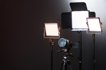 Professional lighting equipment and camera on color background. Space for text