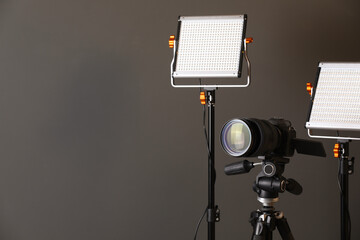 Professional lighting equipment and camera on grey background. Space for text