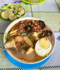 Warm Lighting, Creamy Broth Noodle Bowl with Iced Tea and Condiments