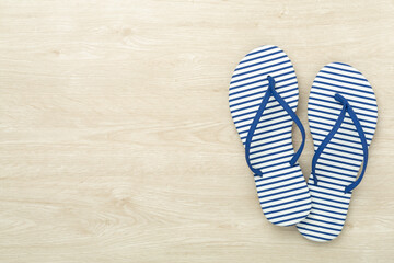 Striped blue flip flops on wooden background, top view