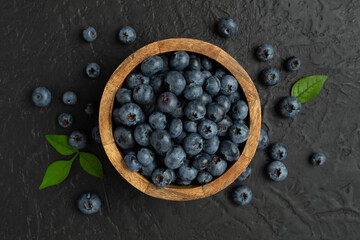 Bowl with fresh bright blueberries on concrete background,top view