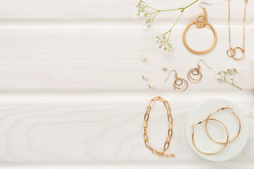 Elegant golden jewelry with decoration on wooden background, top view