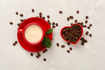 Cup of coffee with coffee beans and leaves on concrete background,top view