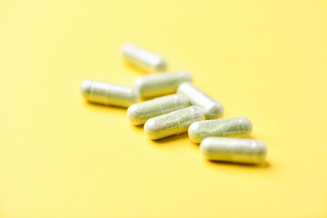 Barley grass capsules. Antioxidants. Concept for a healthy dietary supplementation. Bright background. Soft focus. Close up. Copy space.