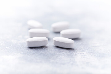 Amino acids tablets on wooden background. Soft focus. Close up	