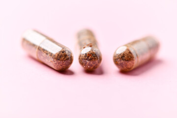 Obraz premium Siberian ginseng (Eleutherococcus senticosus) capsules on bright background. Soft focus. Close up. Copy space. 