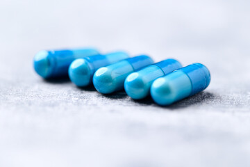 Amino acids capsules on bright wooden background. Soft focus. Close up. Copy space.	