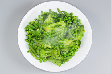Freshly boiled green vegetables mixture on dish, top view