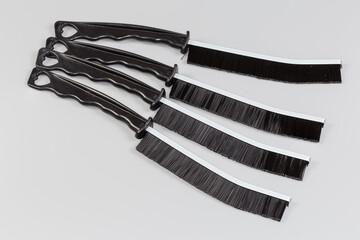 Universal fine brushes with hard plastic bristles and ergonomic handles