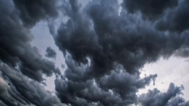Dramatic dark clouds rolling across sky during sunset transition