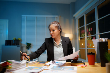 Exhausted businesswoman works late into the night, overwhelmed by stress, deadlines, and endless...