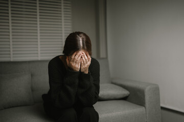 Worried woman sits alone in deep contemplation—struggling with anxiety, loneliness, and emotional...