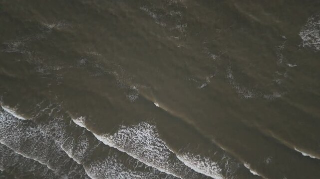 Rising Above: Aerial Shot of Waves at Sunset