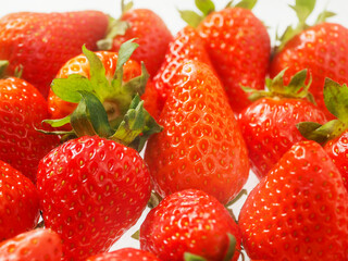 Close up of pile of strawberry. Fine fruits. White background. Tasty snack. Agriculture industry and food supply.