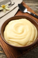 Tasty vanilla pudding served on wooden table, closeup
