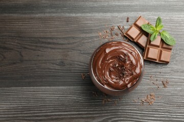 Delicious pudding in glass, chocolate and mint on wooden table, flat lay. Space for text