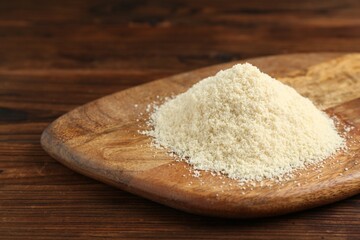Pile of flour on wooden table, closeup. Space for text