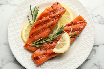 Seafood. Tasty grilled salmon served with rosemary and lemon on white marble table, top view