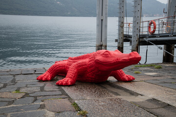 Red Crocodile Sculpture Emerging from Lake Maggiore in Cannobio, Italy
