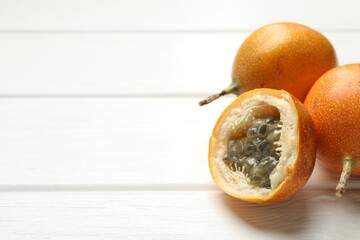 Ripe passion fruits on white wooden table, closeup. Space for text