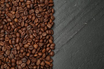 Aromatic coffee beans on black table, flat lay. Space for text