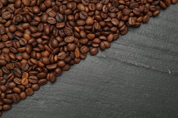 Aromatic coffee beans on black table, flat lay. Space for text